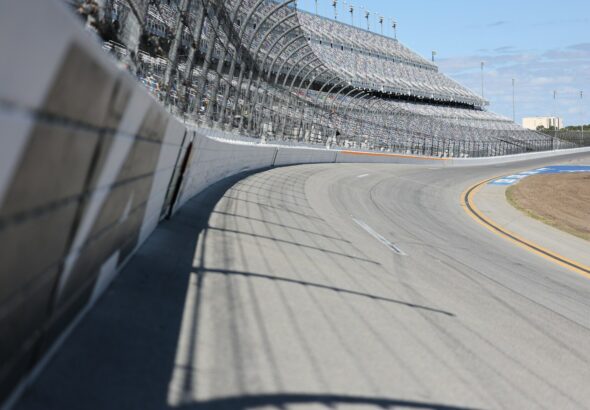 A racetrack curve and grandstands are shown.