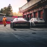 white coupe beside red coupe during daytime