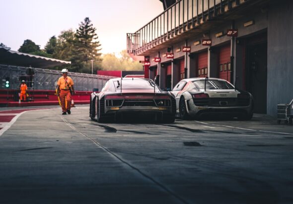 white coupe beside red coupe during daytime
