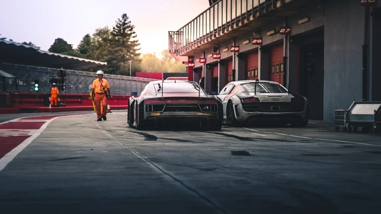 white coupe beside red coupe during daytime