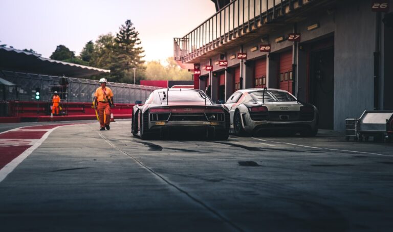white coupe beside red coupe during daytime