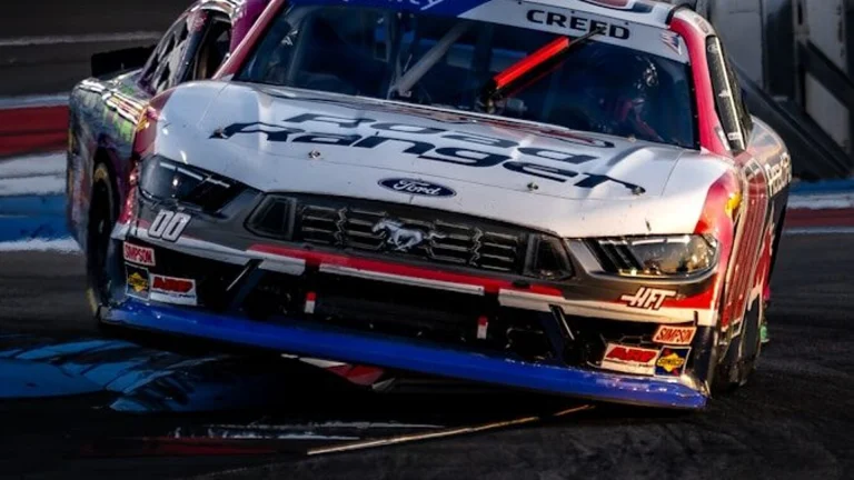 Race cars speed around a track during a race.