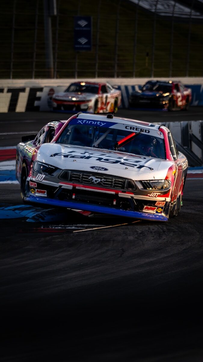 Race cars speed around a track during a race.