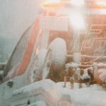 a white truck driving down a snow covered road