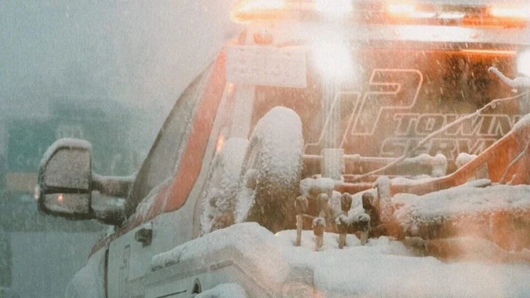 a white truck driving down a snow covered road