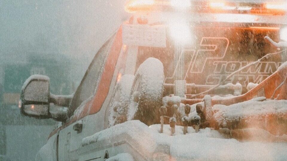 a white truck driving down a snow covered road