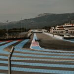 A race track with a boat in the background