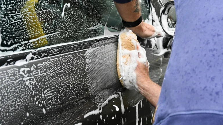 a man washing a car with a sponge