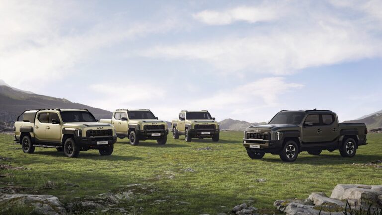 A group of four trucks parked in a field
