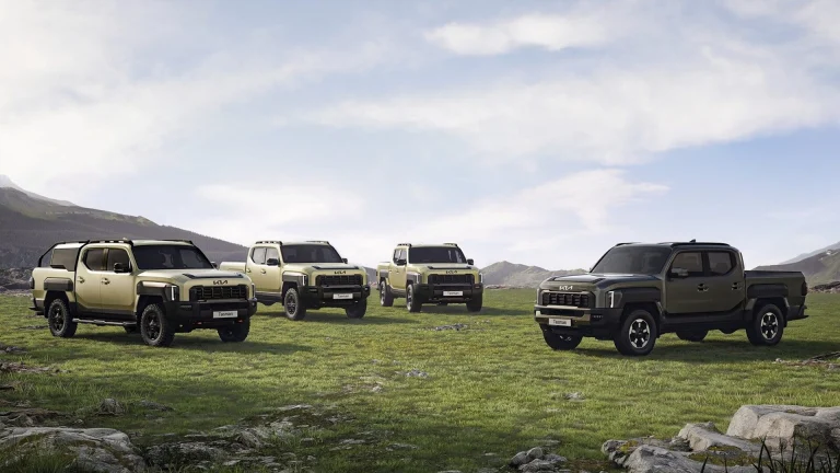 A group of four trucks parked in a field