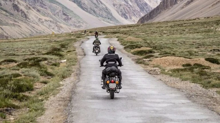 two motorcycles driving on grey road