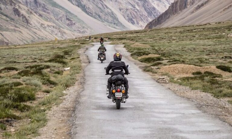 two motorcycles driving on grey road