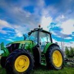 a tractor parked in a field with a blue sky in the background