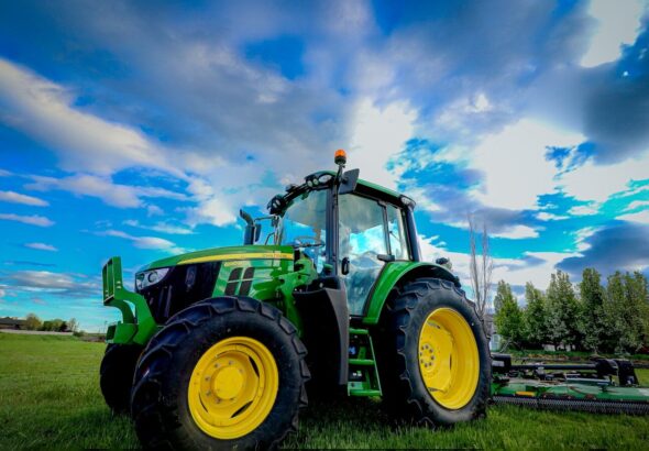 a tractor parked in a field with a blue sky in the background