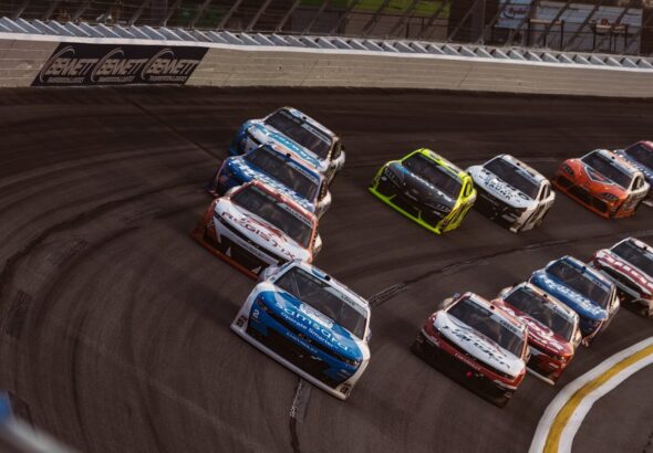 Stock cars racing on a track during a competition.