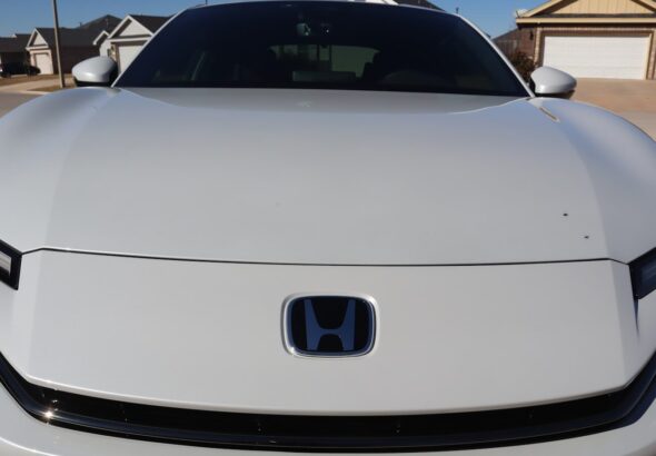 White car with blue honda logo on hood
