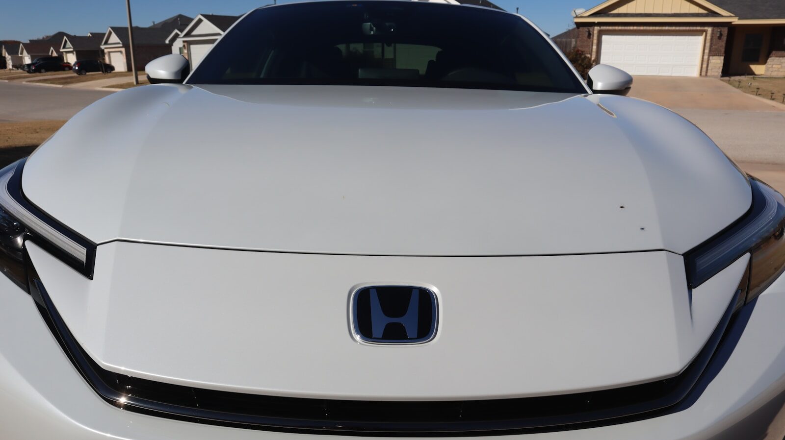 White car with blue honda logo on hood