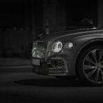 Front view of a luxury car with a chrome grille at night