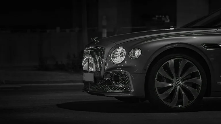 Front view of a luxury car with a chrome grille at night
