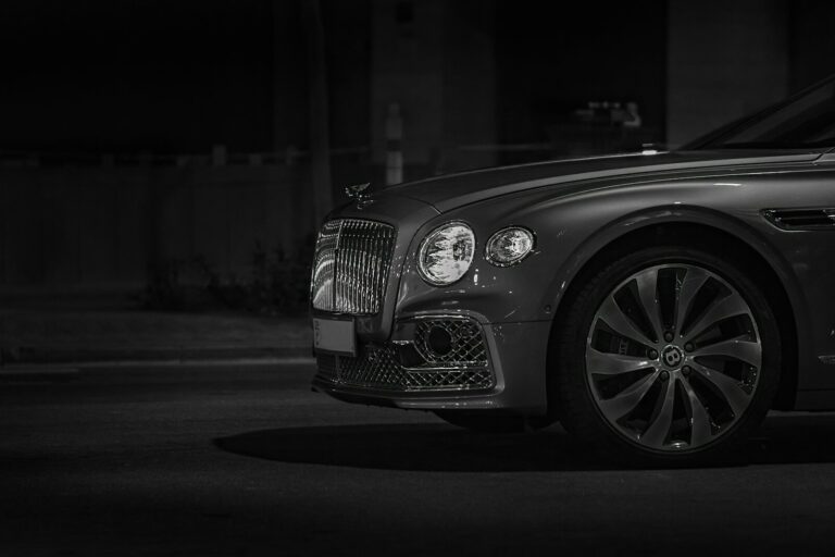 Front view of a luxury car with a chrome grille at night