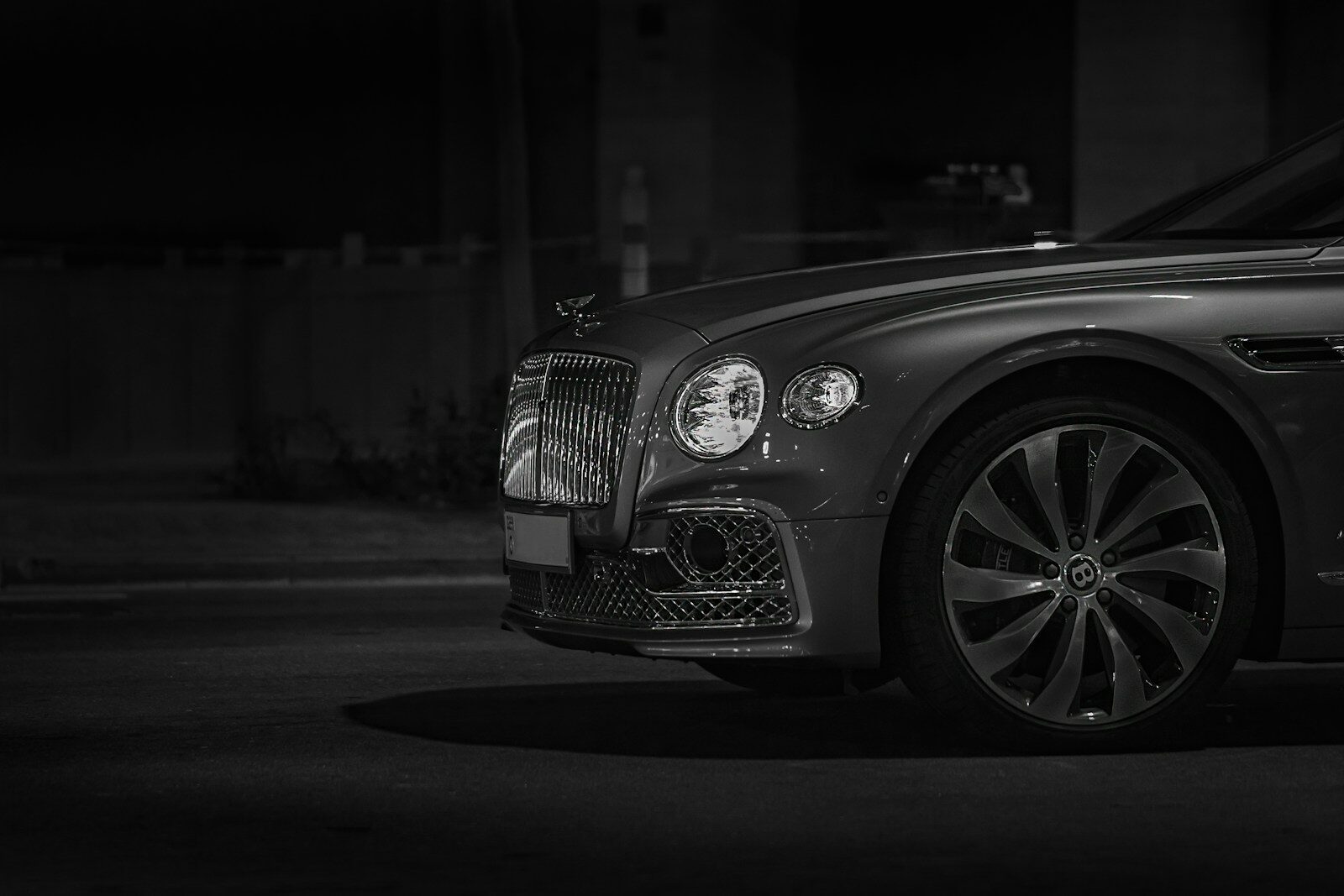 Front view of a luxury car with a chrome grille at night