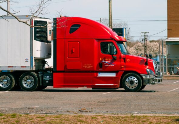 red and white truck on road during daytime