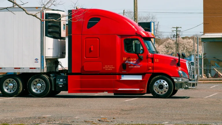 red and white truck on road during daytime