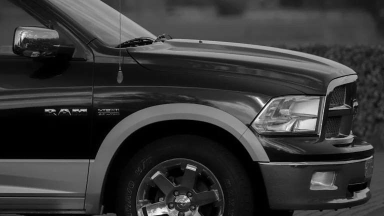 A black pickup truck with chrome wheels parked on a paved surface