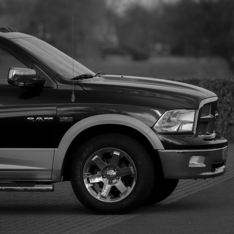 A black pickup truck with chrome wheels parked on a paved surface