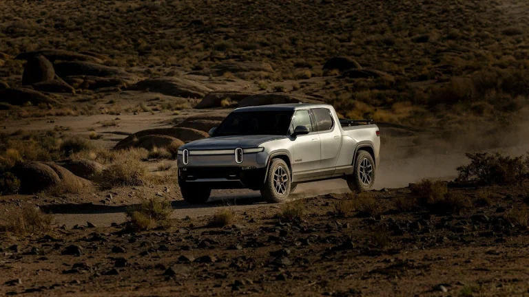 a white truck driving down a dirt road