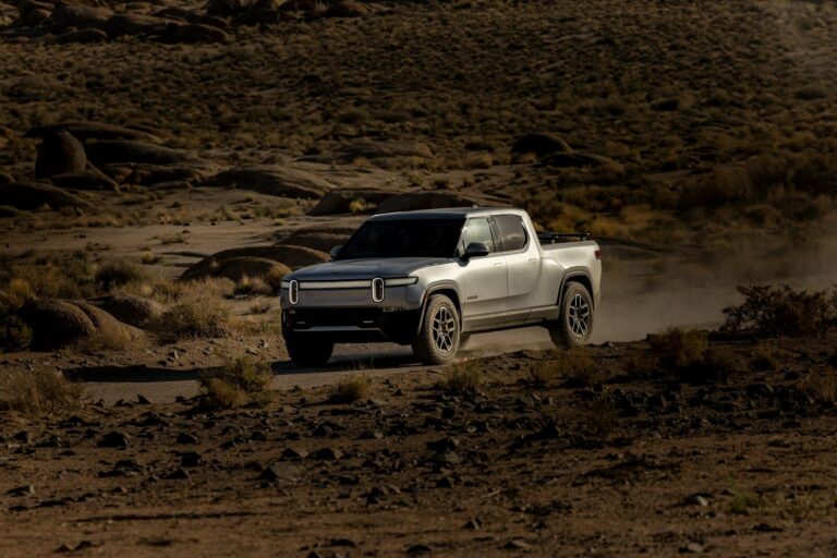 a white truck driving down a dirt road