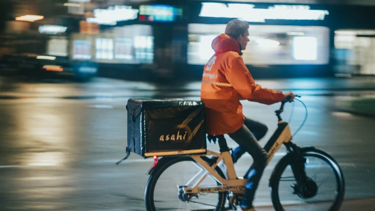 a man riding a bike down a street at night