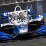 Blue and white race car speeding on track