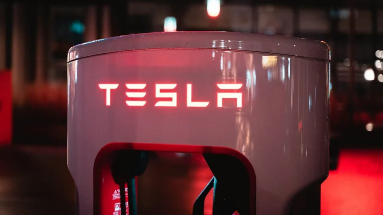 a red tesla logo on a white machine