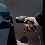 a man in a suit is pumping gas into a car