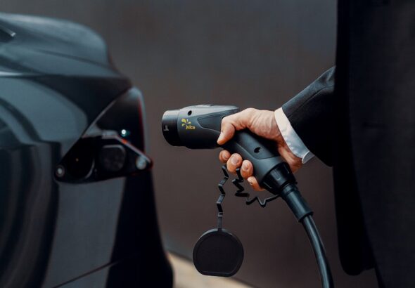 a man in a suit is pumping gas into a car