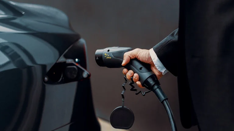 a man in a suit is pumping gas into a car