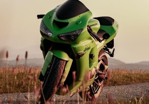 A bright green sport motorcycle parked on a road.