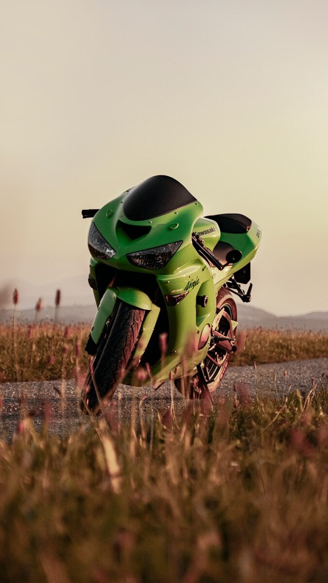 A bright green sport motorcycle parked on a road.