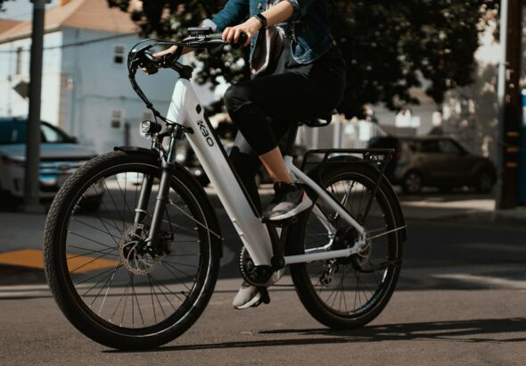 man in black jacket riding on white and black bicycle