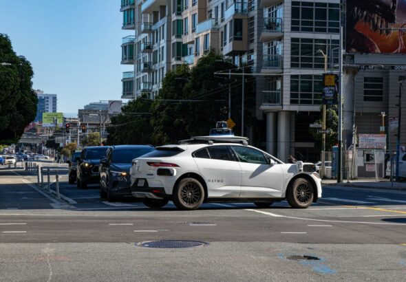 A white car is stopped at an intersection