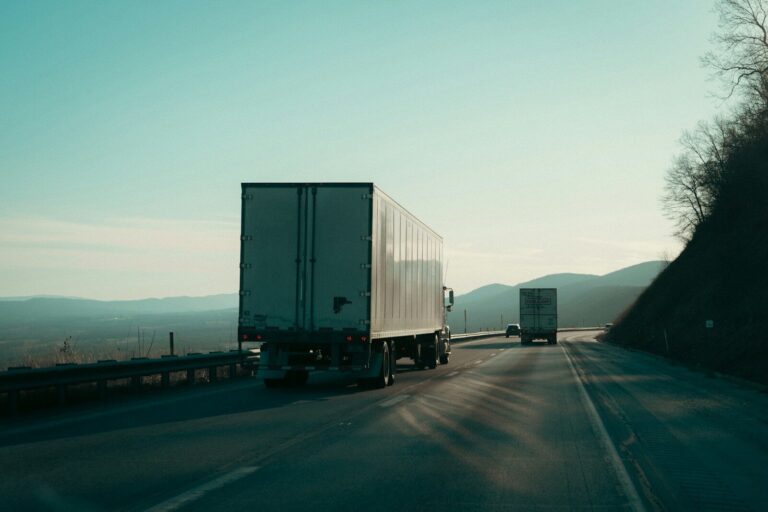 Two semi-trucks driving on a highway