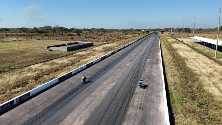 Two motorcycles racing on a long asphalt track