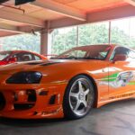 Iconic orange customized sports car on display.