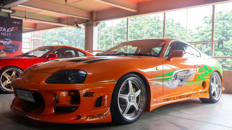 Iconic orange customized sports car on display.