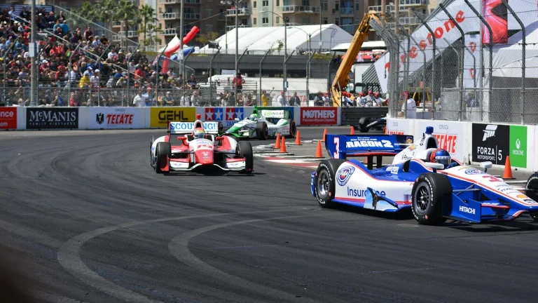 a group of racing cars driving down a race track