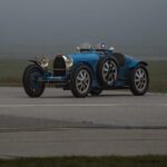 a blue race car driving down a runway