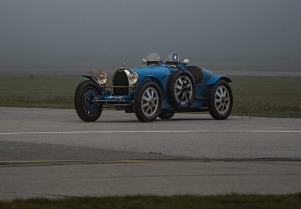a blue race car driving down a runway