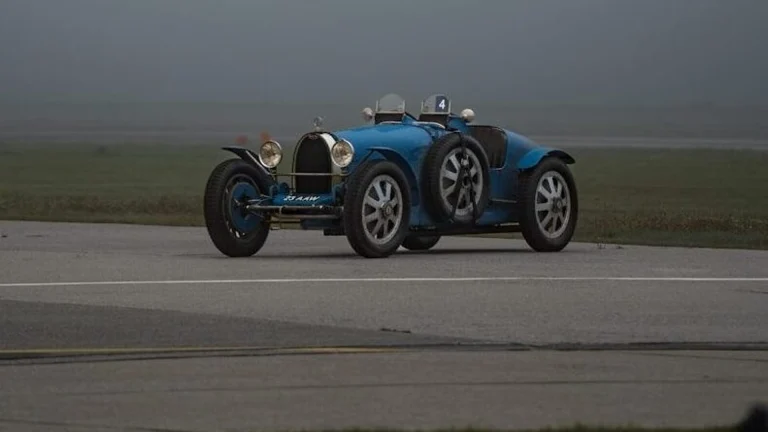 a blue race car driving down a runway