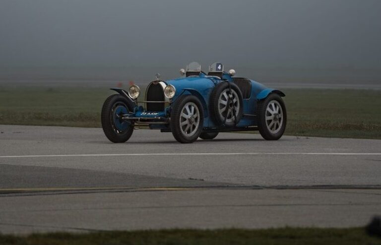 a blue race car driving down a runway